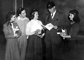 Fenn Pres. G. Brooks Earnest wears a freshman beanie while talking with a group of freshmen, ca.1953.